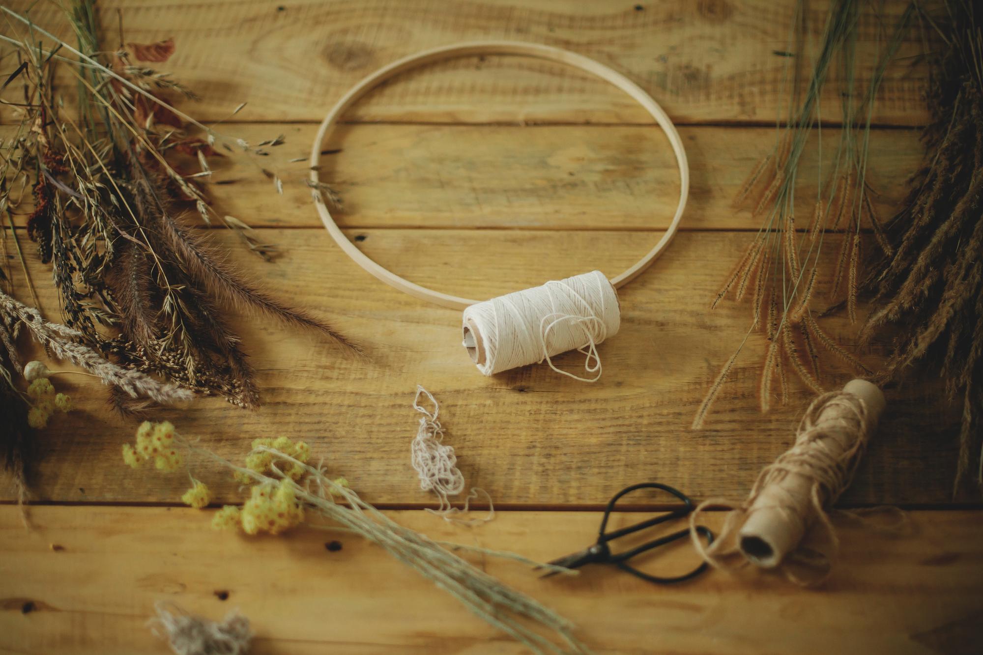 Studio workspace with threads and hoops on wooden table